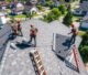 Professional crew performing roof replacements on a US suburban home