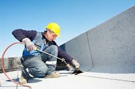 Workers installing a new flat roof membrane on a modern building