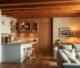 Cozy basement kitchenette with open kitchen design, bar seating, and warm lighting for entertainment space.